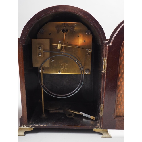 158 - A mahogany arch topped mantel clock with silvered dial and Roman numerals, 8 1/2