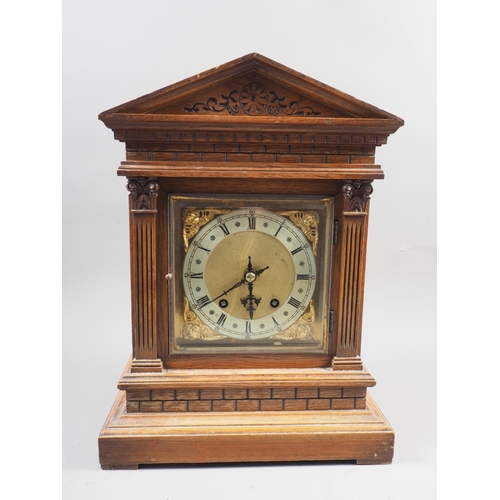 160 - An oak cased mantel clock with carved decoration, silvered and gilt dial, and Roman numerals, on blo... 