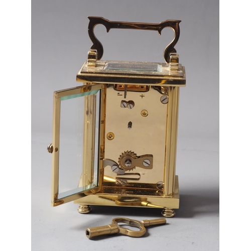 165 - A David Peterson brass cased carriage clock with Swiss movement, white enamel dial and Roman numeral... 