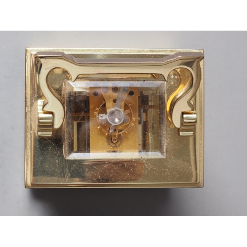 165 - A David Peterson brass cased carriage clock with Swiss movement, white enamel dial and Roman numeral... 