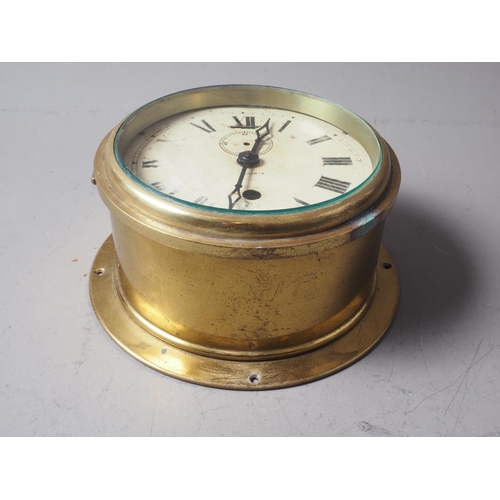 169 - An Armstrong of Manchester brass cased bulkhead clock with Roman numerals and enamelled dial, 7 1/2