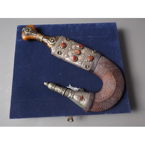 235 - An Islamic Hijaz Jambiya with white metal and leather sheath inset semi-precious stones, in case