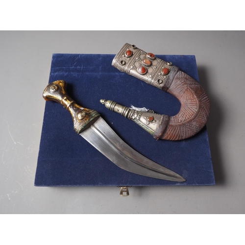 235 - An Islamic Hijaz Jambiya with white metal and leather sheath inset semi-precious stones, in case