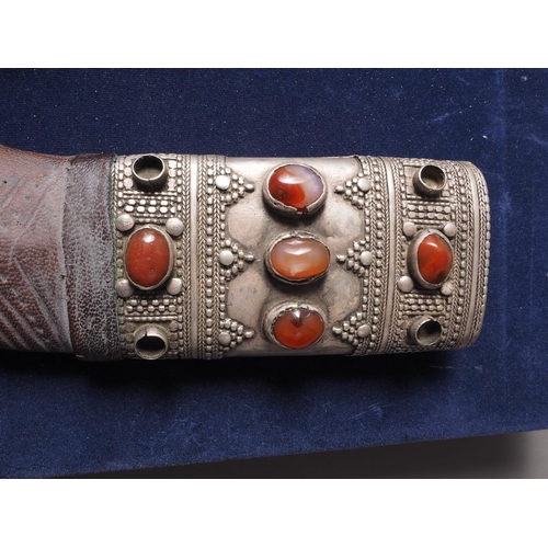 235 - An Islamic Hijaz Jambiya with white metal and leather sheath inset semi-precious stones, in case