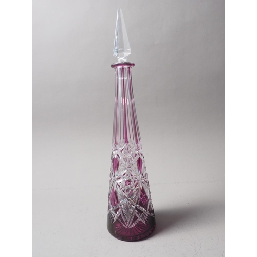 69 - An amethyst overlaid glass decanter with spearpoint stopper, 16 1/2