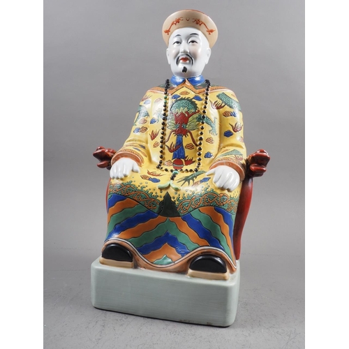 98 - A Chinese porcelain figure of a seated mandarin, in yellow jacket, 19