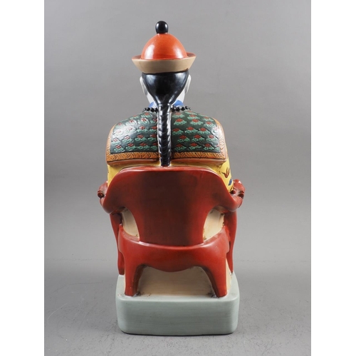 98 - A Chinese porcelain figure of a seated mandarin, in yellow jacket, 19