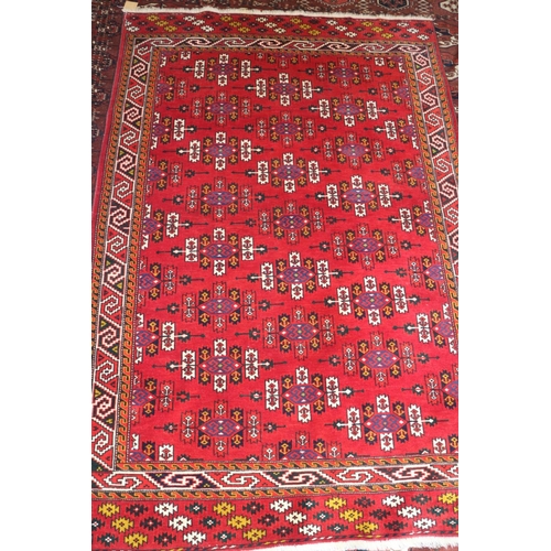 575 - A Caucasian rug with shaped guls, on a red ground and multi-geometric borders, 75