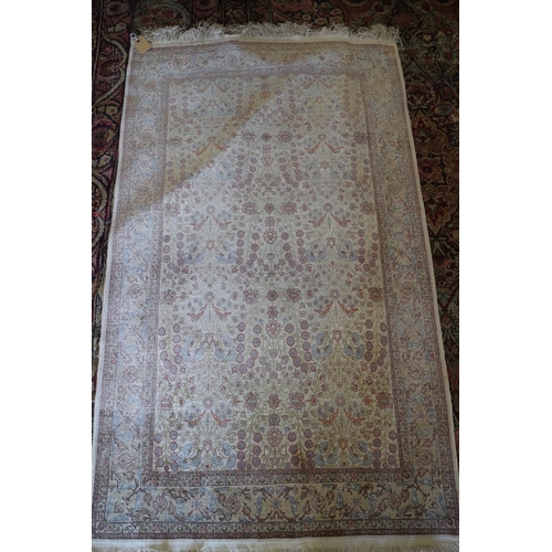 577 - A Qum silk rug with all-over garden design in shades of cream, blue, green and red, signed, 72