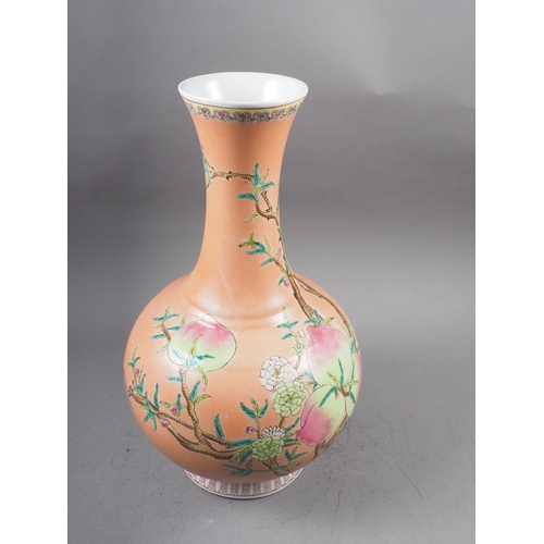 115 - A Chinese bulbous vase with peach and flower decoration on an orange ground and six-character mark t... 