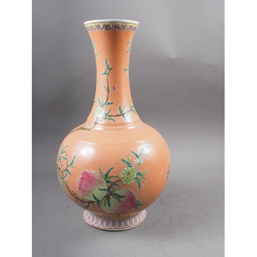 115 - A Chinese bulbous vase with peach and flower decoration on an orange ground and six-character mark t... 