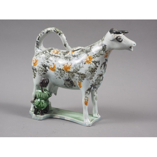 13 - An early 19th century Yorkshire pearlware sponge decorated cow creamer and milkmaid, 5 1/2