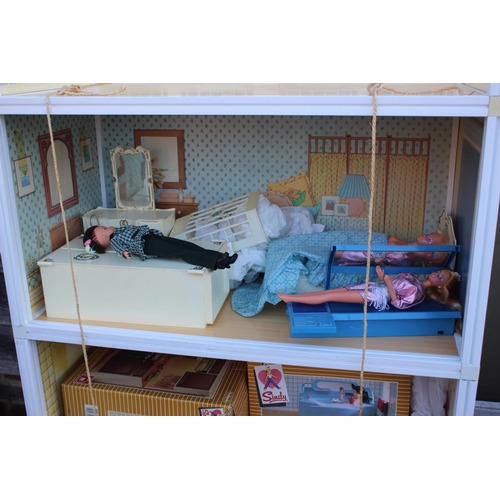 185 - A Sindy three-storey doll's house, two Sindy dolls, a selection of Sindy doll's furniture comprising... 