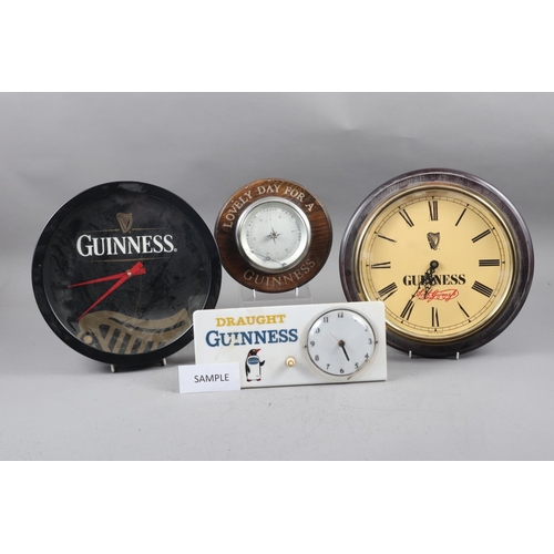 233 - A Draught Guinness bar top clock, two Guinness wall clocks, an oak cased barometer and various other... 