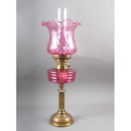 265 - A Victorian oil lamp with pink glass shade and reservoir, on fluted column and circular base, 23 1/4... 