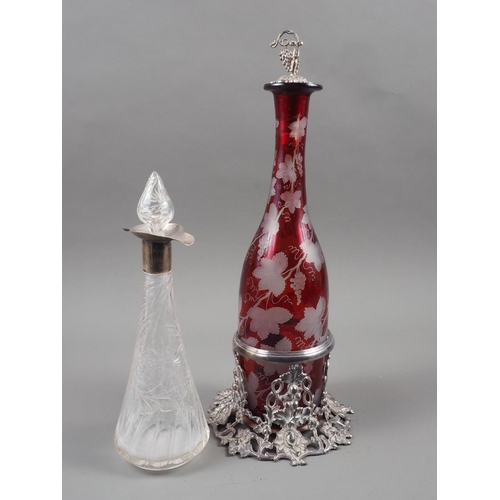 288 - A ruby flashed and vine leaf edged decanter, on silver plated vine leaf stand with matching stopper,... 