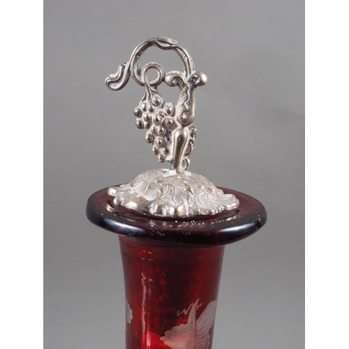 288 - A ruby flashed and vine leaf edged decanter, on silver plated vine leaf stand with matching stopper,... 