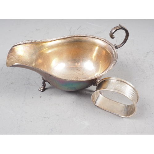 307 - A silver sauce boat with scroll handle and three paw supports, and a silver napkin ring, 3.0oz troy ... 