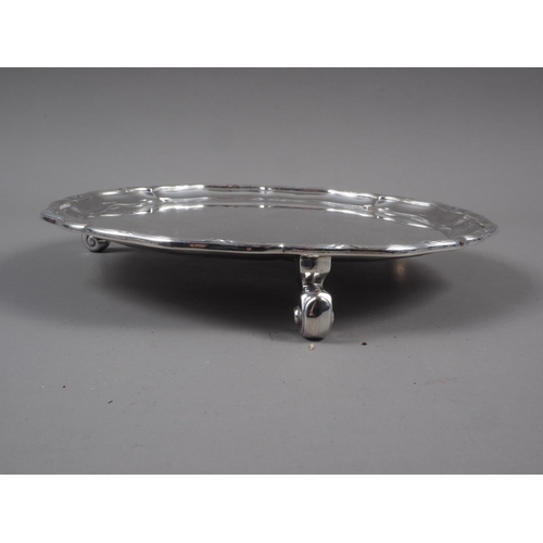 317 - A silver pie crust card tray, on three scrolled feet, 12.3oz troy approx