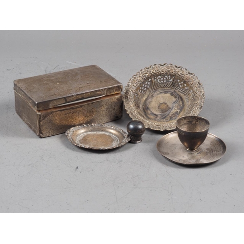 323 - A silver cigarette box (damages), a silver egg cup and two silver pin dishes