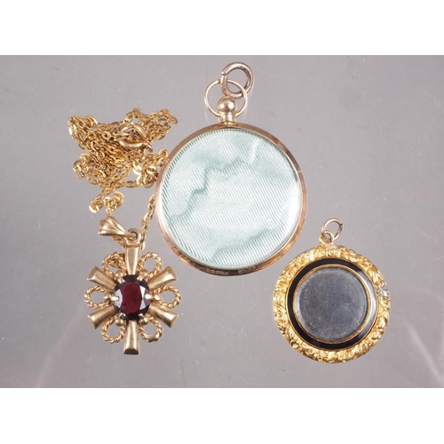 364 - A 9ct gold garnet set pendant, a yellow metal framed locket, and an engine turned and enamelled lock... 