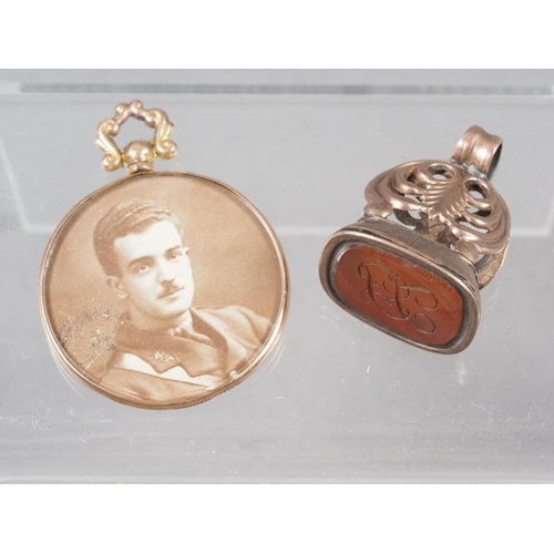 372 - A yellow metal and carnelian fob seal, and a 9ct gold framed locket pendant