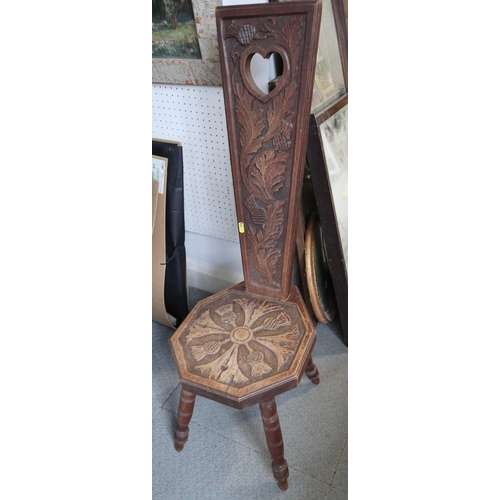 492 - A carved oak spinning stool, on splay supports