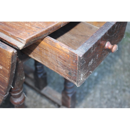 494 - An oak oval drop leaf dining table, on turned and stretchered gate leg supports, 43