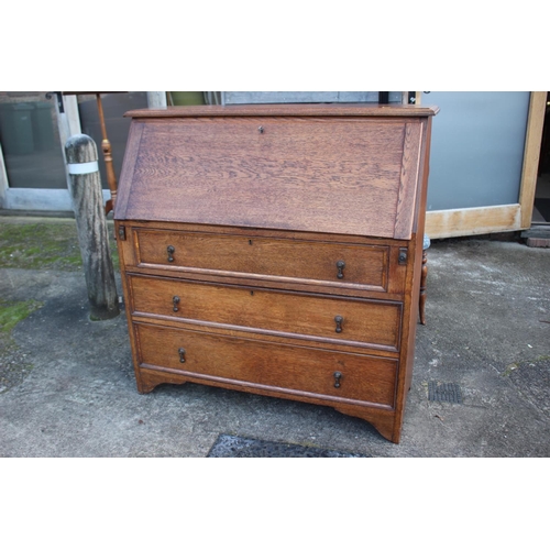 511 - An Edwardian oak fall front bureau with fitted interior over three drawers, on bracket feet, 42