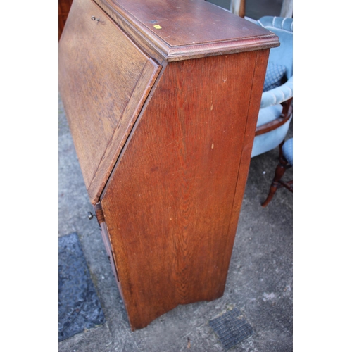 511 - An Edwardian oak fall front bureau with fitted interior over three drawers, on bracket feet, 42