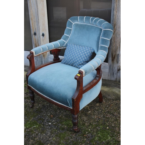 514 - An Edwardian walnut showframe tub-shape open armchair, upholstered in a blue velour, on turned and c... 