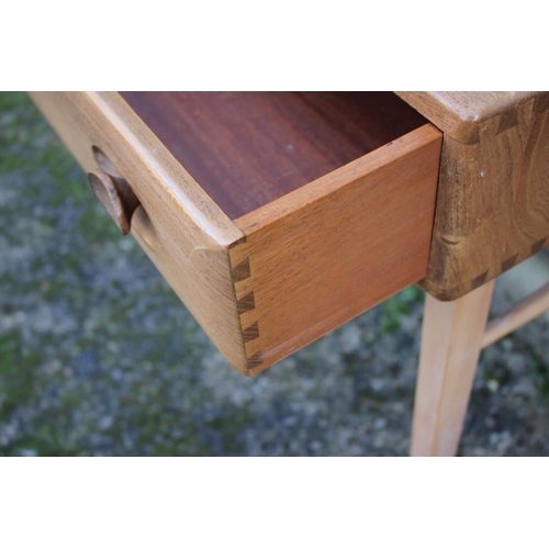 519 - A 1960s Ercol elm and beech writing table, 437/439, with stationery compartments over one long drawe... 