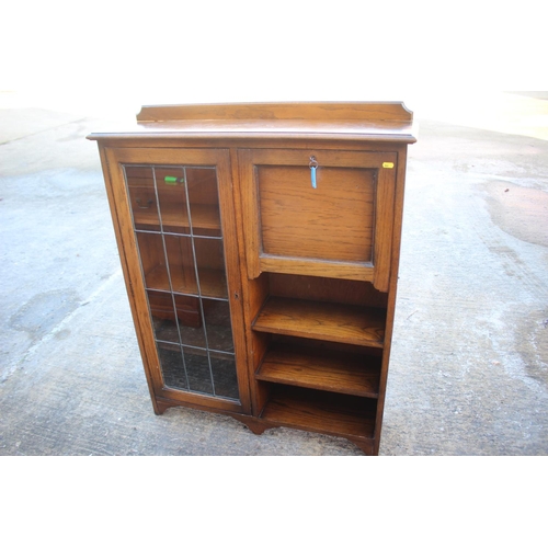 525 - An early 20th century oak desk/book case enclosed leaded glazed door and fall front writing compartm... 