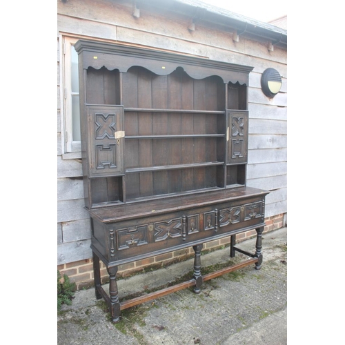 529 - An oak dresser of 18th century design, the upper section fitted shelves and two spice cupboards, ove... 