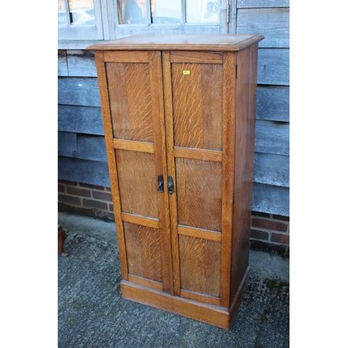 531 - A 1920s oak cupboard enclosed two panelled doors, on block base, 24