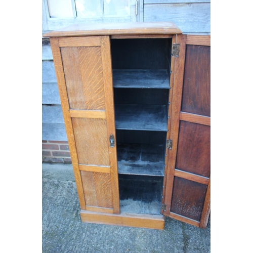 531 - A 1920s oak cupboard enclosed two panelled doors, on block base, 24