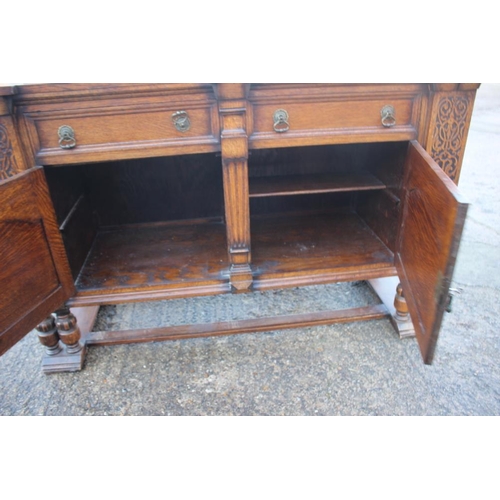 537 - A 1930s carved oak breakfront sideboard, fitted two drawers over two doors, on cluster column suppor... 