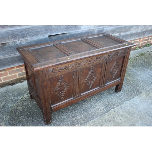 569 - A three panel oak coffer with carvings to panels and frieze, 49