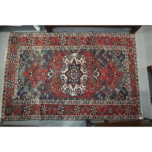 586 - A Hamadan rug with central white medallion on a rust ground and floral borders, 50