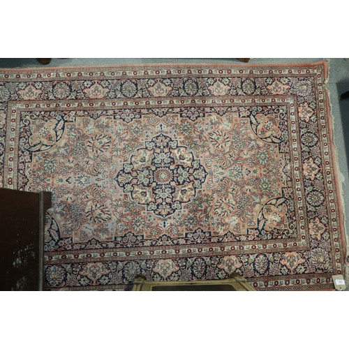 587 - A Kashan design rug with all-over floral design on a pink ground and blue ground floral border, 47