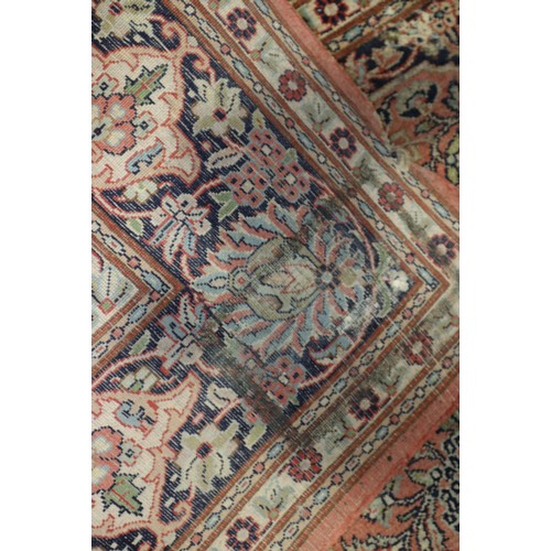 587 - A Kashan design rug with all-over floral design on a pink ground and blue ground floral border, 47