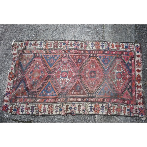 588 - A Kazak style rug with four hooked medallions, 69