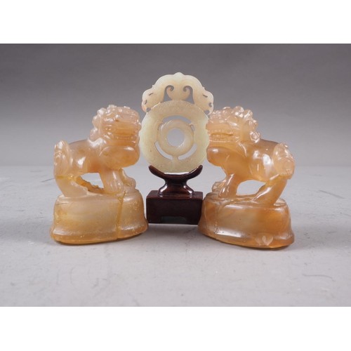 113 - A Chinese green jade roundel with carved and pierced decoration, on stand, 2 3/4