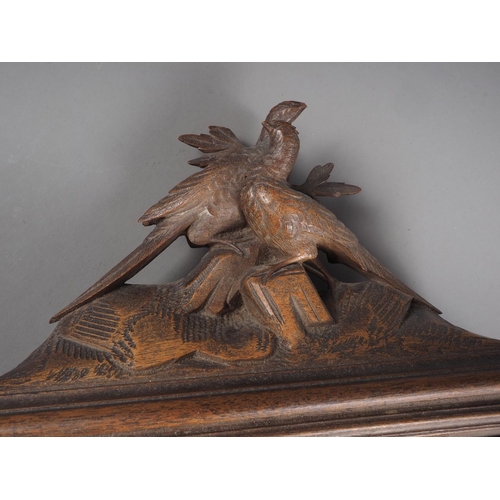 168 - A 19th century carved walnut black forest type letterbox with pheasant surmount, 22