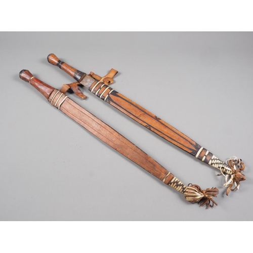 173 - Two African swords with leather scabbards, blades 17