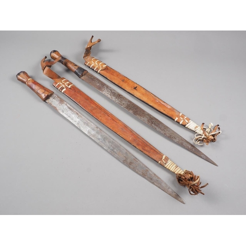 173 - Two African swords with leather scabbards, blades 17