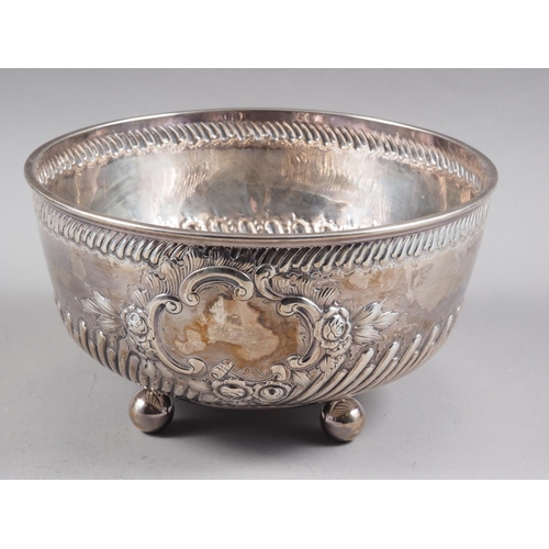 317 - A Victorian silver bowl with embossed decoration, on four bun feet, 9 1/2