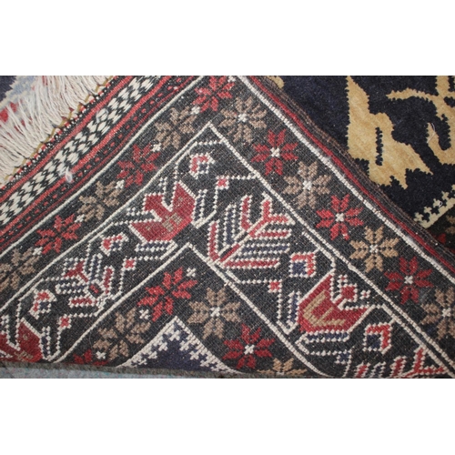 648 - A Persian tribal rug with architectural floral panels on a blue ground, 52