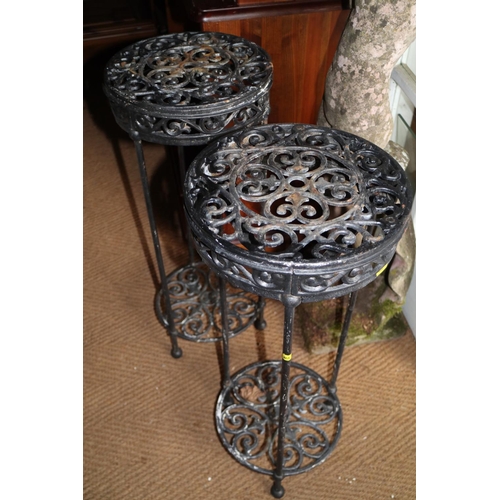 664 - A pair of cast iron circular topped two-tier garden tables, 11 1/2