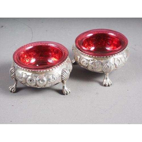 282 - A pair of Victorian silver salt cellars with embossed floral decoration, on paw supports, 4oz troy a... 